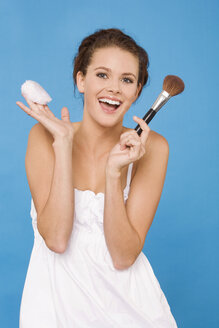Junge Frau mit Make-up-Pinsel und Puderquaste, lachend - RDF00738