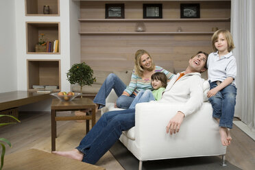 Family sitting on sofa, smiling, portrait - WESTF08122