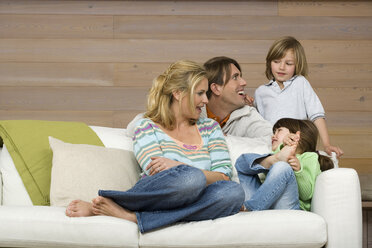 Family sitting on sofa, smiling, portrait - WESTF08119