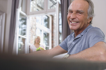 Älterer Mann am Tisch sitzend, lächelnd, Porträt - WESTF08227