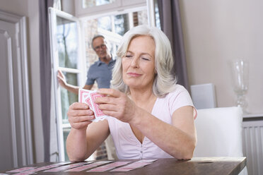 Ältere Frau spielt Solitaire, älterer Mann im Hintergrund, Porträt - WESTF08221