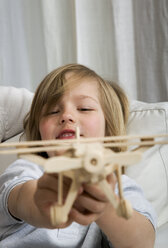 Junge (8-9) hält Spielzeugflugzeug, Porträt - WESTF08057