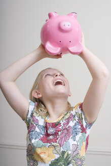 Girl (8-9) with piggy bank, portrait - WESTF08350