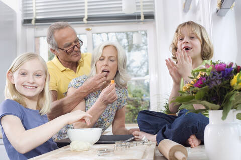 Großeltern und Enkelkinder (8-9) in der Küche, Porträt, lizenzfreies Stockfoto