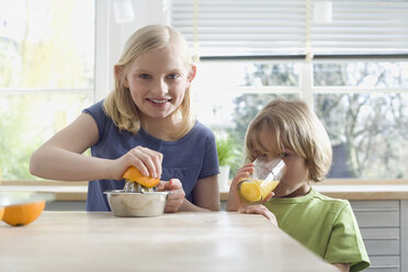 Junge und Mädchen (8-9) bereiten frischen Orangensaft zu, Porträt - WESTF08292