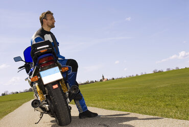 Germany, Bavaria, Biker with motorbike, taking a break - NHF00769