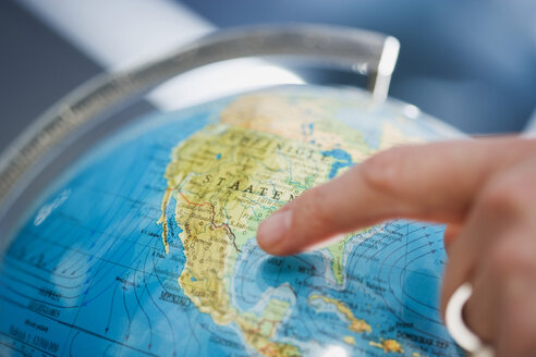 Person pointing at a globe - HKF00248