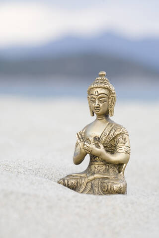 Buddha-Figur auf Sand, Nahaufnahme, lizenzfreies Stockfoto