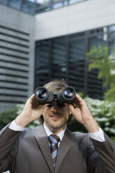 Germany, Baden-Württemberg, Stuttgart, Businessman looking through field glass - WESTF08775