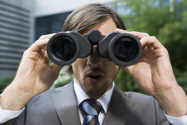 Germany, Baden-Württemberg, Stuttgart, Businessman looking through field glass - WESTF08774