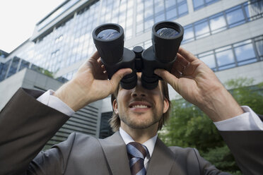 Germany, Baden-Württemberg, Stuttgart, Businessman using field glasses - WESTF08773