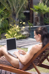 Junge Frau benutzt Laptop im Schwimmbad - ABF00365
