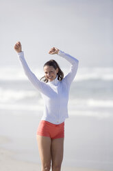 Junge Frau am Strand, Arme hoch - ABF00340