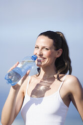 Junge Frau trinkt Wasser, Porträt - ABF00331