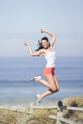 Junge Frau springt am Strand - ABF00323