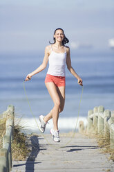 Young woman using skipping rope - ABF00321