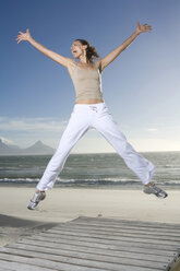 South Africa, Cape Town,Young woman jumping on beach - ABF00278