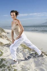Südafrika, Kapstadt, Junge Frau trainiert am Strand - ABF00272