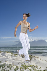 Südafrika, Kapstadt, Junge Frau joggt am Strand - ABF00267