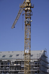 Deutschland, Bayern, München, Baukran neben einem Gebäude - TCF00835