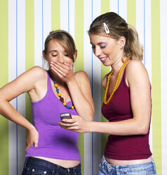 Two teenage girls (16-17) using mobile phone, portrait - JLF00294