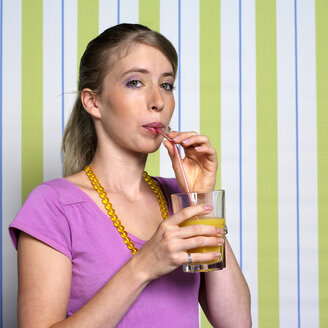 Teenage girl (16-17) drinking orange juice, portrait - JLF00282