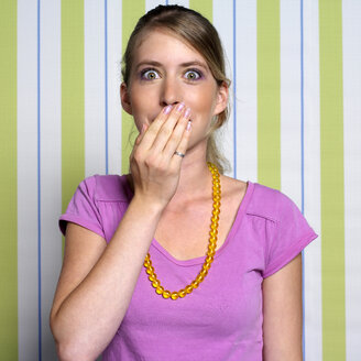 Teenage girl (16-17) covering mouth with hand, portrait - JLF00275