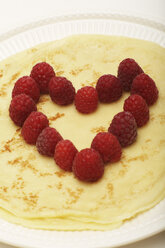 A close-up of a heart-shaped pancake topped with fresh raspberries - SCF00176