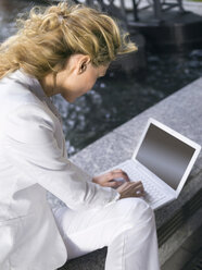 Germany, Baden-Württemberg, Stuttgart, Young businesswoman using laptop, elevated view - WESTF08836