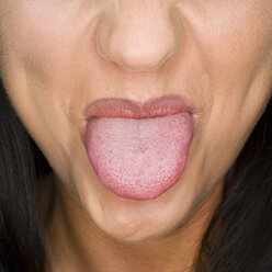 Woman sticking out tongue, close-up - MUF00584