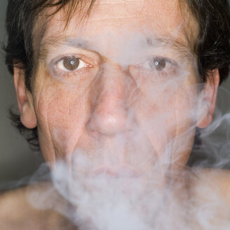 Mann beim Ausatmen von Zigarettenrauch, Nahaufnahme, Porträt - MUF00573