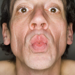 Man pursing lips, portrait, close-up - MUF00564