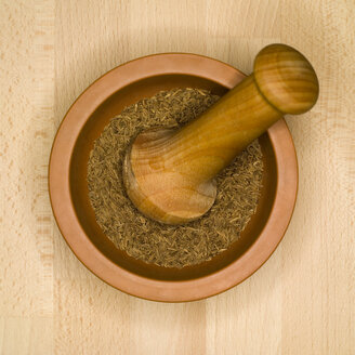 Cumin seeds in mortar with pestle, elevated view - MUF00557