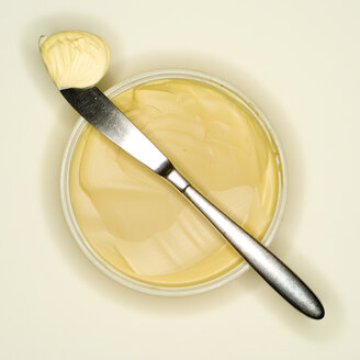 Margarine curl lying on back of a knife, elevated view - MUF00518