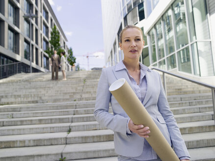 Germany, Baden-Württemberg, Stuttgart, Businesswoman with roll, businesspeople in background - WEST08661