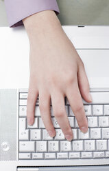 Woman typing on computer, one hand, elevated view - BMF00387