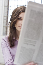 Junge Geschäftsfrau im Büro, liest Zeitung - BMF00354