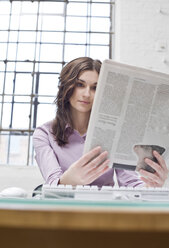 Junge Geschäftsfrau im Büro, liest Zeitung - BMF00353
