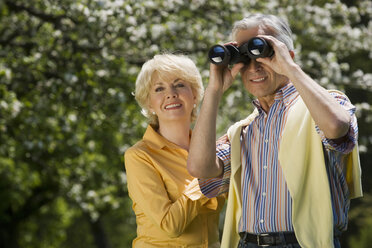 Germany, Baden Württemberg, Tübingen, Senior couple, senior man looking through binoculars - WESTF08907