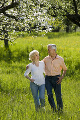 Germany, Baden Württemberg, Tübingen, Senior couple walking across field - WESTF08857