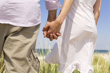 Germany, Baltic sea, Couple holding hands, rear view - WESTF09348