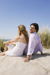 Deutschland, Ostsee, Junges Paar entspannt auf grasbewachsener Sanddüne - WESTF09333