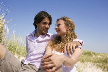 Germany, Baltic sea, Young couple sitting in dunes, portrait - WESTF09326