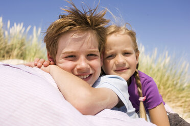 Germany, Baltic sea, Boy (8-9) and girl (6-7) in sand dunes, smiling, portrait, close-up - WESTF09314
