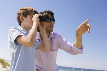 Germany, Baltic sea, Boy (8-9) looking through binoculars, portrait - WESTF09296