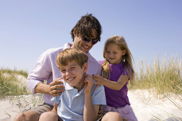 Germany, Baltic sea, Father and children on sand dunes, portrait - WESTF09292