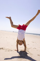 Germany, Baltic sea, Girl (6-7) doing handstand on beach - WESTF09209