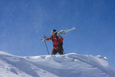 Austria, Tyrol, Zillertal, Gerlos, Freeride, Man carrying skis over shoulders - FFF00916
