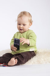 Kleiner Junge (1-2) spielt mit Mobiltelefon - RDF00938