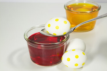 Easter eggs beside glasses of dye - GWF00847